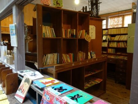 古い本棚に囲まれた本屋スペースの写真